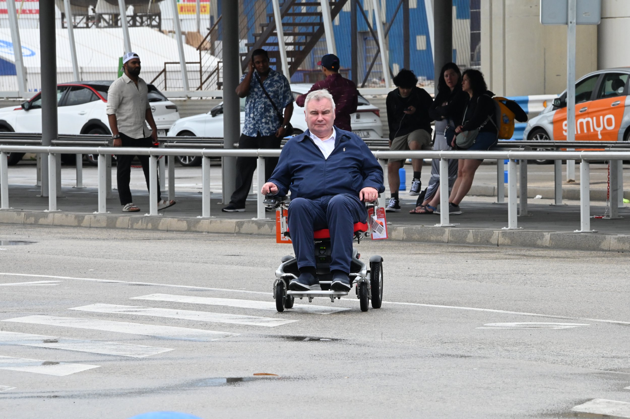 Eamonn Holmes steering himself through Barcelona Airport on a wheelchair